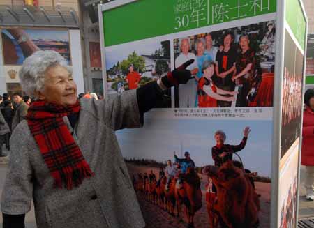 Chen Shihe points herself in a picture at an exhibition featuring China's 30 years' reform and opening-up at Wangfujing Street in Beijing, capital of China, on Dec. 16, 2008. The photo exhibition presenting near 800 pictures in memory of the past 30 years' development was unveiled here on Tuesday.