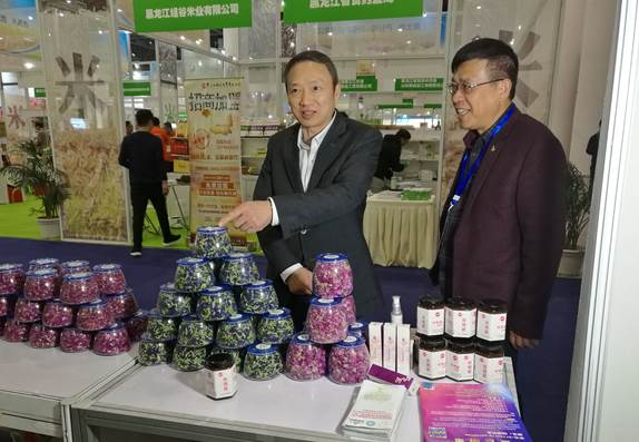省委臺(tái)辦主任周敏謙(左)在四川雙龍農(nóng)牧開發(fā)有限公司展臺(tái)與臺(tái)商林云飛(右)親切交流