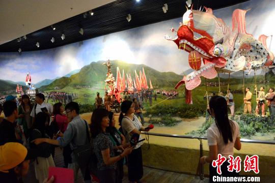 圖為兩岸記者、青年學生在龍巖市博物館了解閩西客家民俗活動�！埥鸫āz
