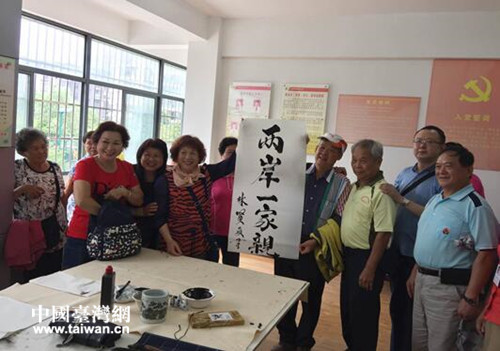 林賢文在古田街春天社區(qū)現(xiàn)場(chǎng)書寫“兩岸一家親”
