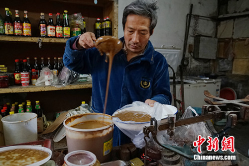 王老板在給顧客舀醬。中新網記者 李卿 攝