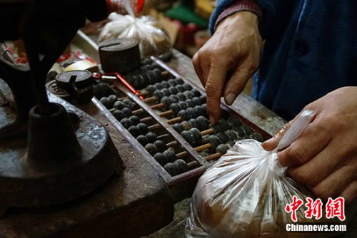 現(xiàn)在，王老板仍保留著用算盤算賬的習慣。中新網記者 李卿 攝