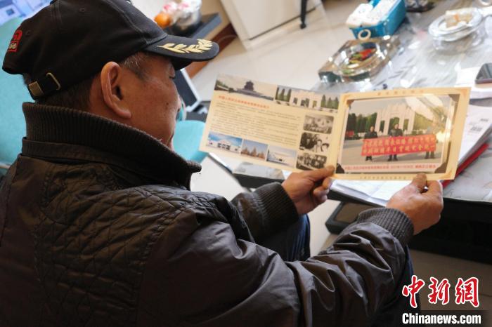 陳文仁拿出相冊，講述騎行故事。　王鵬 攝