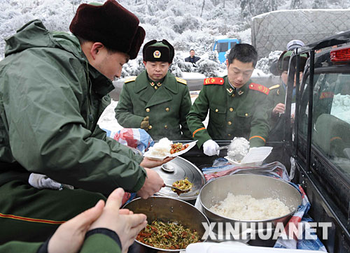 　2月2日，湖南消防總隊(duì)郴州消防支隊(duì)的官兵在京珠高速公路堵車現(xiàn)場(chǎng)吃午飯。     由于冰雪天氣造成京珠高速公路嚴(yán)重堵車，湖南消防總隊(duì)郴州消防支隊(duì)300多名官兵十幾天來在京珠高速公路郴州段搶險(xiǎn)救援，為被堵車輛的司機(jī)排憂解難。 　